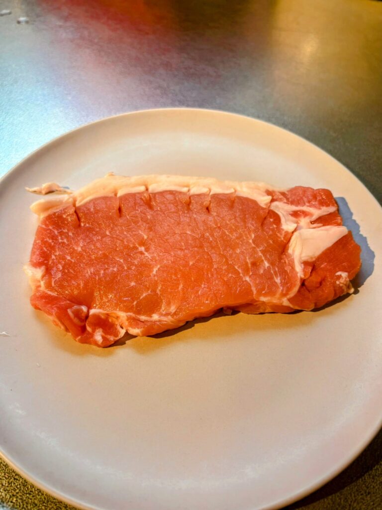 トマトとバジルのポークソテー:豚肉の筋霧をした写真