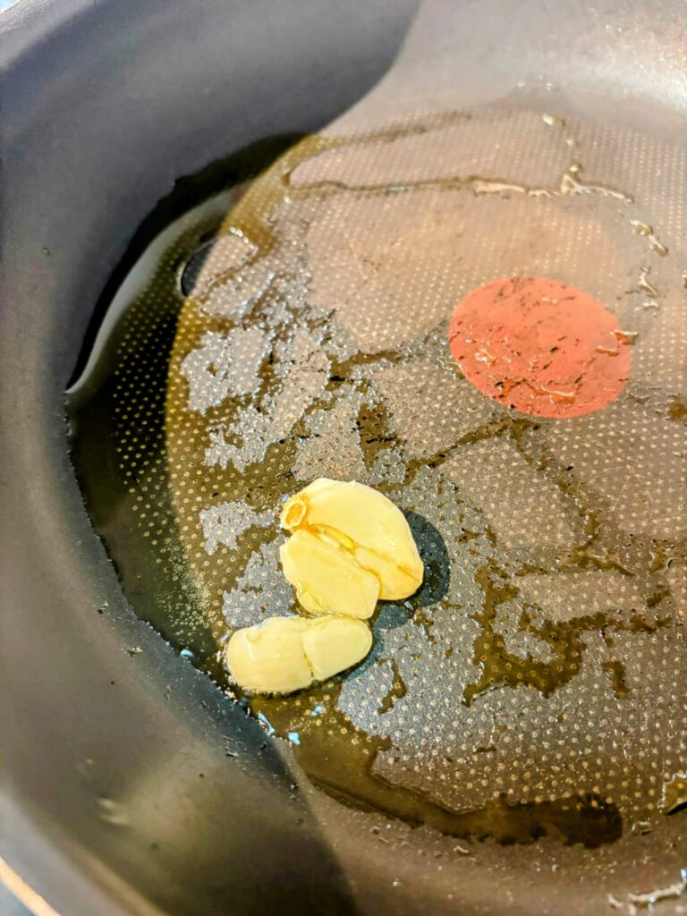 トマトとバジルのポークソテー:オリーブオイルにニンニクを入れた写真